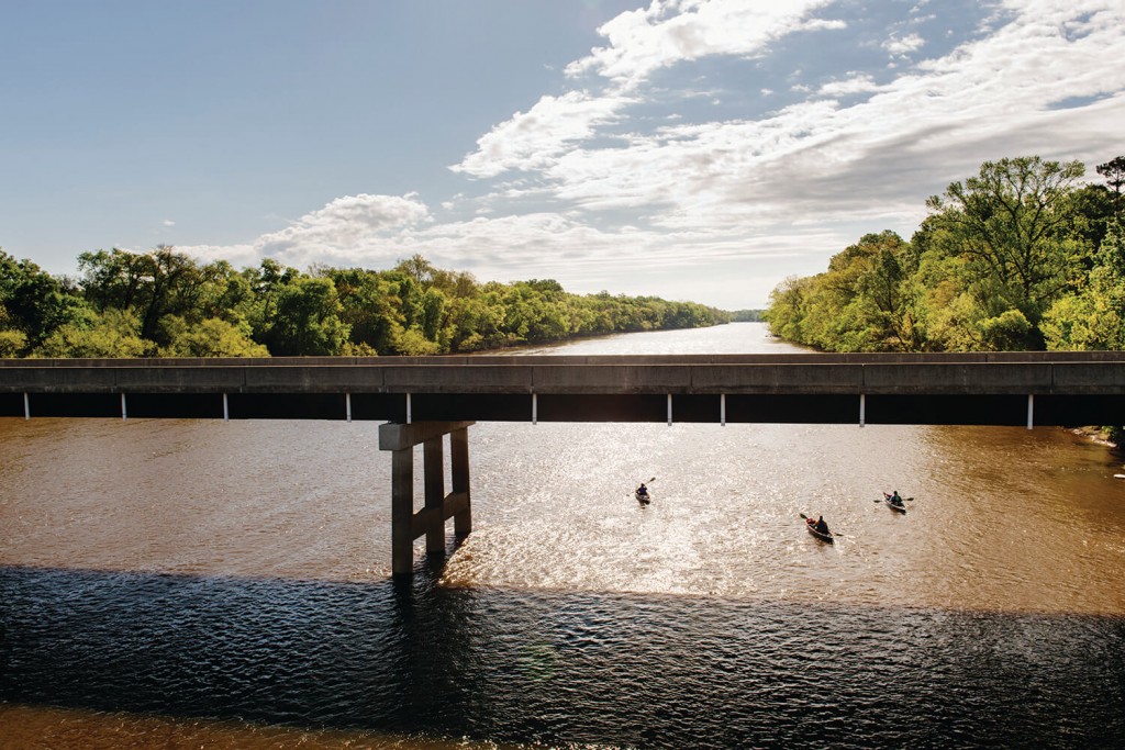 Paddlers, including CFRW's Kemp Burdette, work their way down the Cape Fear River under The Lillington Bridge in North Carolina. Photo: Andrew Kornylak